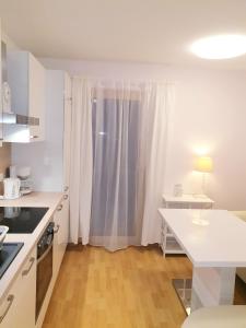 a kitchen with white cabinets and a white counter top at Appartement Fiffinjo in Piesendorf