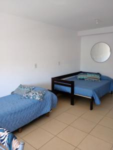 um quarto com 2 camas e um espelho na parede em El Depto de Roberto em Villa María