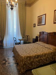 フィレンツェにあるホテル ヴィラ リアナのベッドとテーブルが備わるホテルルームです。