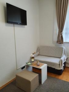 a living room with a couch and a tv on the wall at Studio Apartman 11 in Bihać