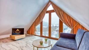 - un salon avec un canapé bleu et une grande fenêtre dans l'établissement Apartament Cicha 11 VIP z SAUNĄ by Royal Aparts, à Świeradów-Zdrój