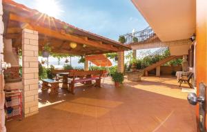 a patio with a wooden bench and a table at 2 Bedroom Gorgeous Apartment In Kostrena in Kostrena