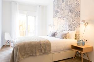 Un dormitorio blanco con una cama grande y una ventana en 'Montano Three' Center by ELE Apartments, en Málaga