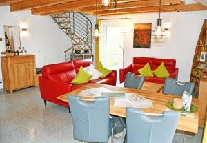 uma sala de jantar com uma mesa e cadeiras vermelhas em Ferienwohnung Selliner Strand em Ostseebad Sellin