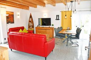 un soggiorno con divano rosso e tavolo di Ferienwohnung Selliner Strand a Ostseebad Sellin
