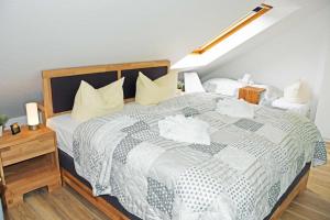 una camera da letto con un grande letto con lenzuola e cuscini bianchi di Ferienwohnung Selliner Strand a Ostseebad Sellin