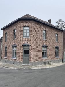 a red brick building with a door on a street at Vakantiewoning Bij de Jep in Bilzen