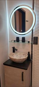 a bathroom with a large stone sink and a mirror at Mini Apartament Rynek in Zakliczyn