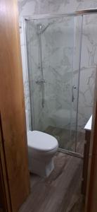 a bathroom with a toilet and a glass shower at Casa do Garrano - Gerês in Vilar da Veiga