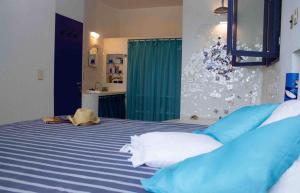 a bedroom with a blue and white bed with blue pillows at Sítio Promontório - Casa Grécia in Ubatuba +14 photos