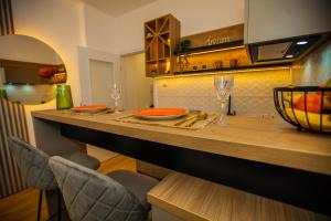 a kitchen with a counter with a table and chairs at Apartman Iskra in Trebinje