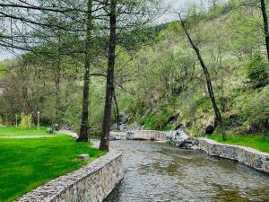 a river with a stone wall next to a park at Domus in natura 