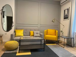 sala de estar con sofá y silla amarilla en Apartments Ella, en Zagreb