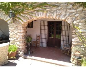 un arco de piedra que conduce a una casa con puerta en Chilliman & Mas Miró Biofarm, en Catllar