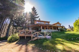 Una casa su una collina con il sole che splende su di essa di Ruca Kuyen Golf & Resort a Villa La Angostura