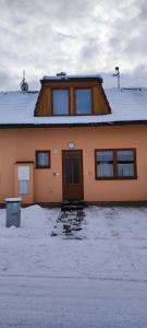 a house with a snow covered roof on top of it at Frymburk Jana in Frymburk