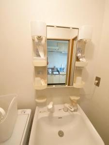 a white bathroom with a sink and a mirror at ラ・フィットヤマト101 in Meinohama