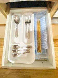 a white tray with silver utensils in a drawer at ラ・フィットヤマト101 in Meinohama