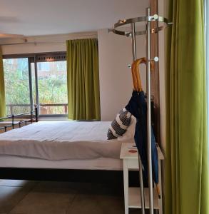 a bedroom with a bed and a green curtain at GREAT CANAL STUDIO - Water view & Free parking in Amsterdam