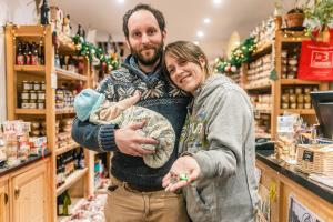 een man en een vrouw die een baby vasthouden in een supermarkt bij L'établisement TOIMOINOU, Hyper-centre, vue marché, proche mer 150m, lits faits à votre arrivée, serviettes de toilette, ménage, inclu, Netflix, accueil en personne in Dieppe