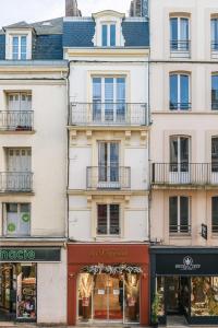 un immeuble de paris avec des boutiques dans une rue dans l'établissement L'établisement TOIMOINOU, Hyper-centre, vue marché, proche mer 150m, lits faits à votre arrivée, serviettes de toilette, ménage, inclu, Netflix, accueil en personne, à Dieppe