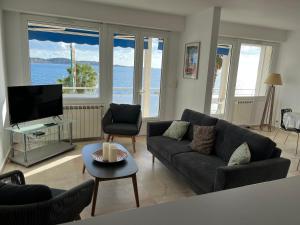 een woonkamer met een bank en een tv bij Bandol le grand horizon in Bandol