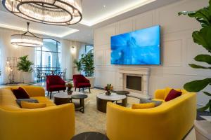 sala de estar con sillas amarillas y chimenea en Hotel Botanica- Limited Edition By Fattal en Haifa