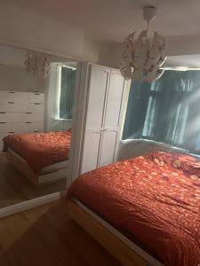 a bedroom with two beds and a mirror and a chandelier at Double Rooms in Shared Home in Enfield