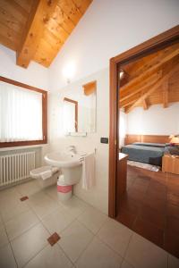 a bathroom with a sink and a toilet and a bed at La Vigneta in Arsiero