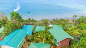 z powietrza widok na ośrodek z niebieskimi dachami i ocean w obiekcie Las Cotingas Ocean View w mieście Bahía Drake