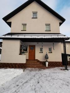 una casa con una puerta delantera en la nieve en Apartament nad Strumykiem en Tylicz