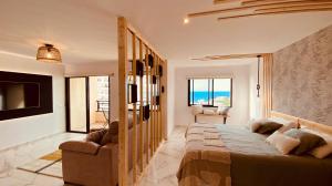 a bedroom with a large bed and a living room at Sunset Paradise in Adeje