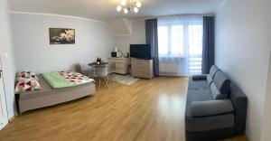 uma sala de estar com uma cama e um sofá em Pokoje gościnne Pod Lwami em Kudowa-Zdrój