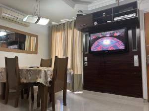 a dining room with a table and a television on a wall at Apartamento Familiar em Campinas 9 solteiros ou 10 se 2 pessoas na cama de casal in Campinas