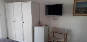 1 dormitorio con TV, silla y armario en B&B Di Marco, en Giardini Naxos