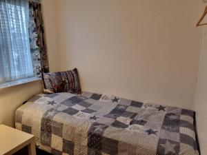 a bedroom with a bed with a quilt on it at Bed and Breakfast Birkerod in Birkerød
