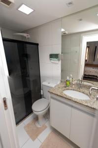 a bathroom with a toilet and a sink and a shower at Apartamento Auto padrão 2 quartos vista mar praia da armação in Salvador
