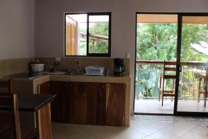a kitchen with a sink and a counter top at TULIN AZUL -Cabina familiar con piscina y cocina equipada, cerca de Jaco- in Tulín