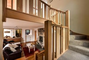 ein Wohnzimmer mit einer Treppe und ein Wohnzimmer mit einem Sofa in der Unterkunft The Steading at Pitmeadow Farm in Dunning