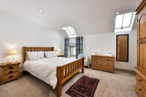 a bedroom with a bed and a dresser and a mirror at The Steading at Pitmeadow Farm in Dunning