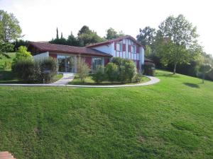 una casa con un césped verde delante de ella en Les Villas d'Harri-Xuria en Saint-Pierre-dʼIrube