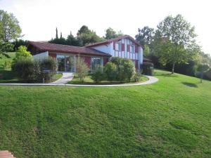una casa con un prato verde davanti di Les Villas d'Harri-Xuria a Saint-Pierre-dʼIrube