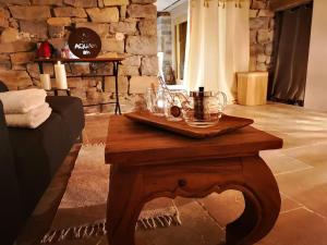 - une table basse dans le salon doté d'un mur en pierre dans l'établissement Hébergement Deluxe avec Grand Jacuzzi et Sauna Millau, à Millau