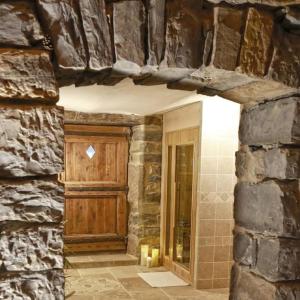 Habitación con puerta de madera y pared de piedra. en Hébergement Deluxe avec Grand Jacuzzi et Sauna Millau, en Millau