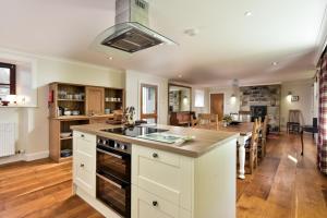 a kitchen with white cabinets and a large island at The Steading at Pitmeadow Farm in Dunning