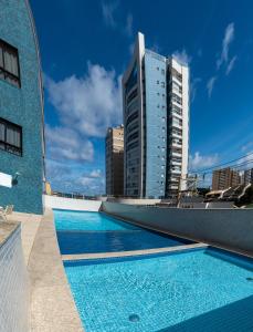 a swimming pool on the side of a building at Apartamento Auto padrão 2 quartos vista mar praia da armação in Salvador