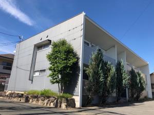 a white building with trees in front of it at ラ・フィットヤマト101 in Meinohama