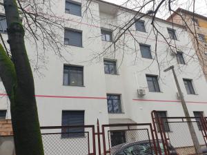 een wit gebouw met ramen en een boom bij Rosé Apartment in Pécs
