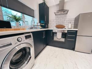 a kitchen with a washer and a washing machine at Hamilton House by Solace Stays in Merthyr Tydfil