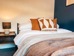 a bedroom with a bed with pillows on it at Hamilton House by Solace Stays in Merthyr Tydfil